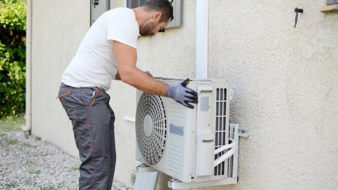 servicio tecnico revisando aparato de aire acondicionado